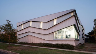 The cladding is LYSAGHT CUSTOM ORB® profile made from COLORBOND® steel in the colours Axis® and Conservatory®, which alternate vertically on the northern face.